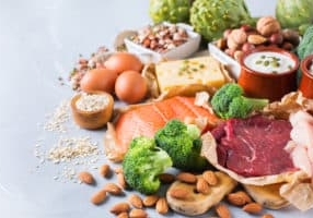Assortment of healthy protein source and body building food. Meat beef salmon chicken breast eggs dairy products cheese yogurt beans artichokes broccoli nuts oat meal. Copy space background